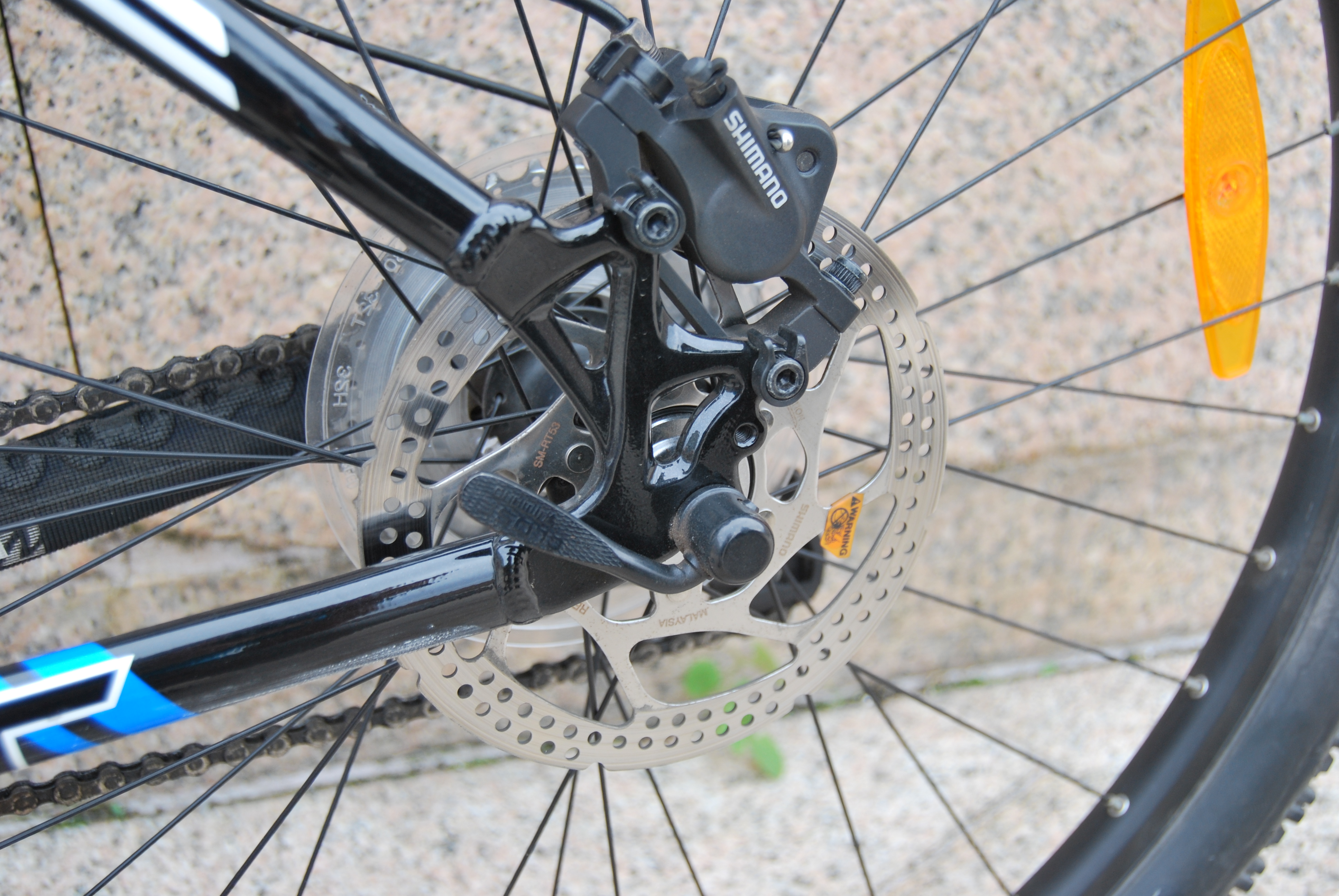 Bicycle rear disc brake caliper and rotor on a Trek wheel