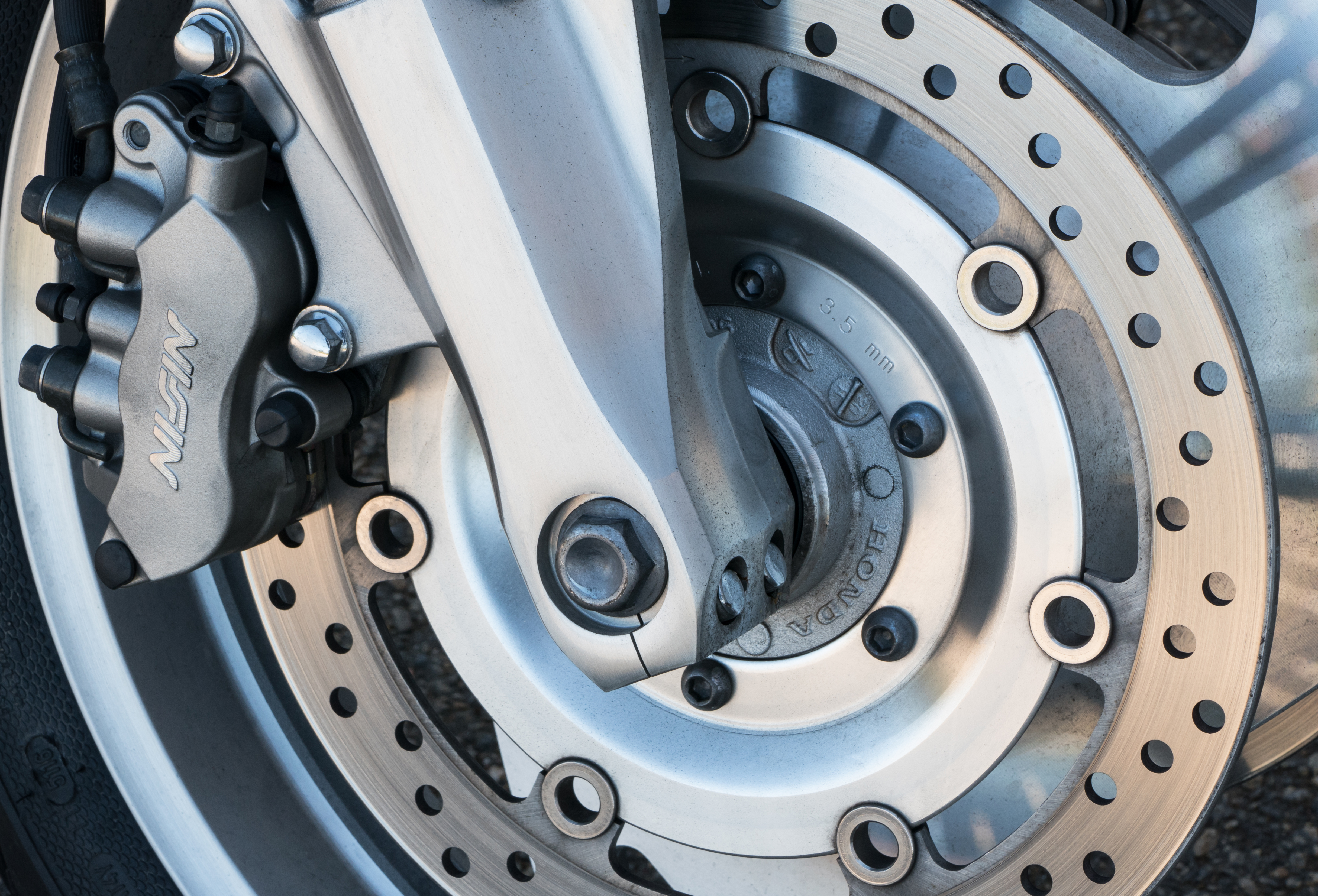 Close-up of a Honda motorcycle front brake caliper and disc