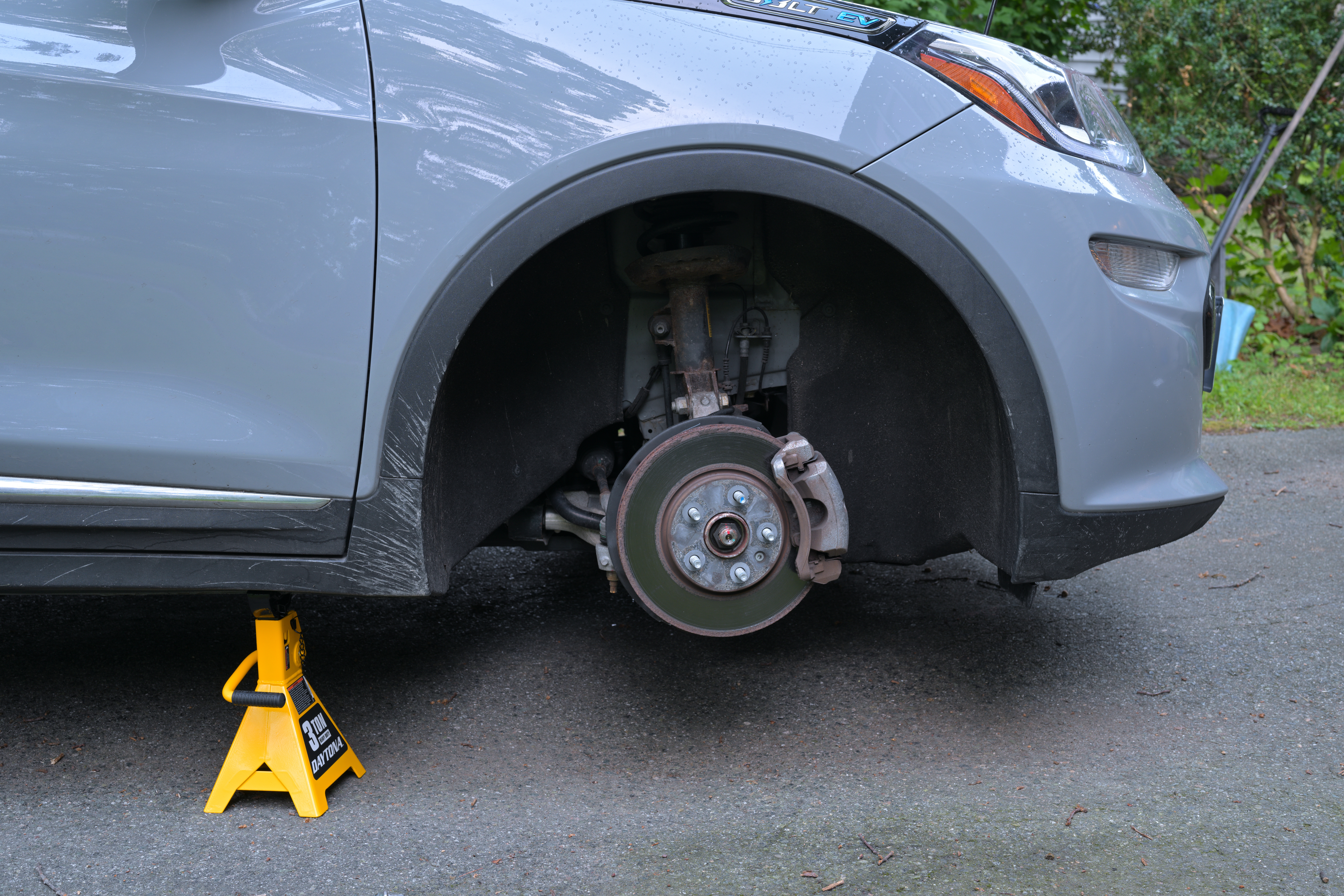 Front disc brake and caliper on a passenger car, cold rotor visible behind the wheel